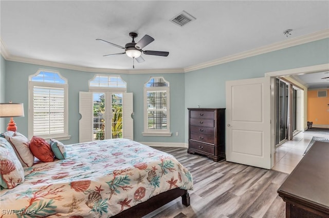 bedroom with ornamental molding, ceiling fan, and light hardwood / wood-style flooring