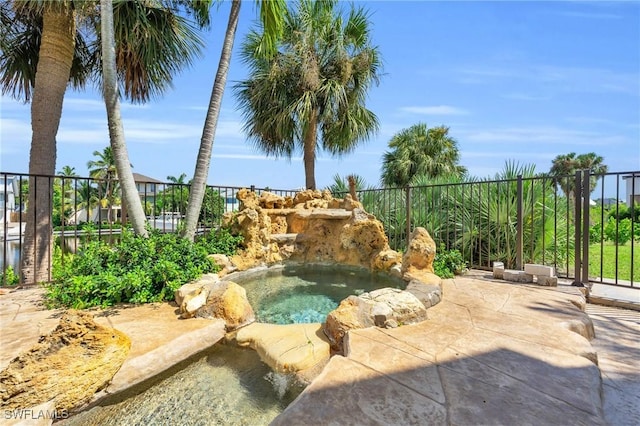 view of swimming pool featuring an in ground hot tub