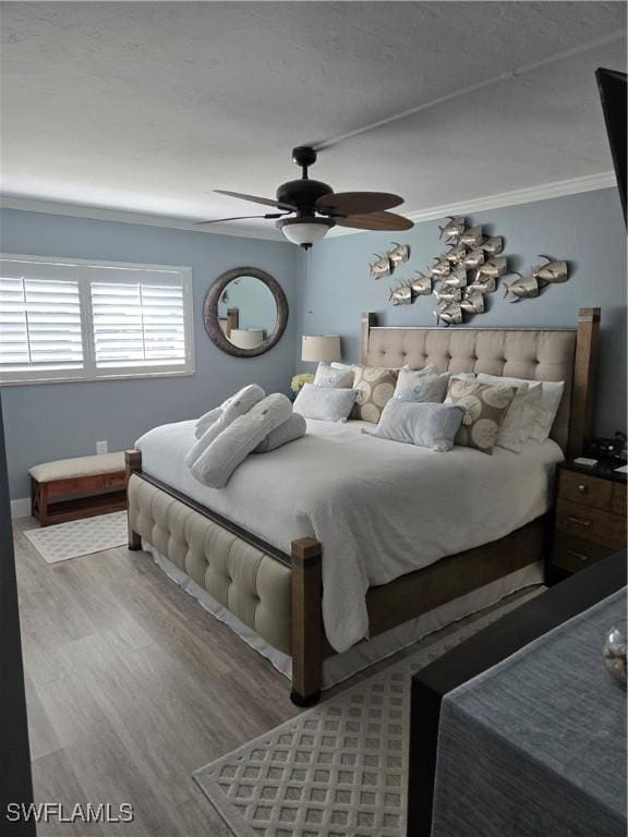 bedroom with hardwood / wood-style flooring, ornamental molding, and ceiling fan