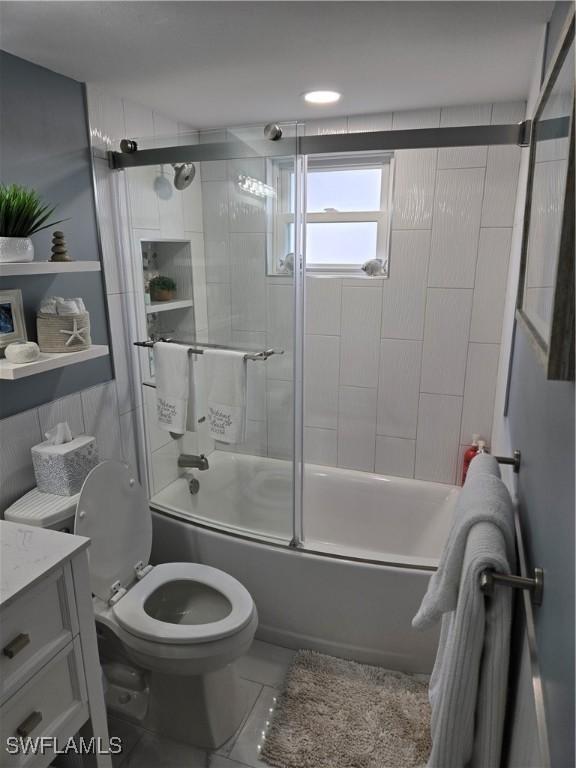 full bathroom with vanity, shower / bath combination with glass door, and toilet