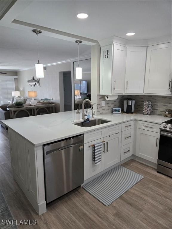 kitchen with sink, kitchen peninsula, white cabinets, and appliances with stainless steel finishes