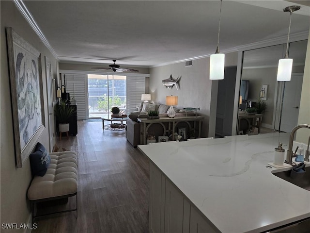 kitchen featuring ornamental molding, dark wood-type flooring, pendant lighting, and ceiling fan