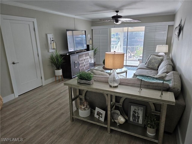 living room with hardwood / wood-style floors, crown molding, and ceiling fan