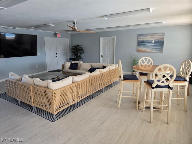 living room featuring ceiling fan and light hardwood / wood-style flooring