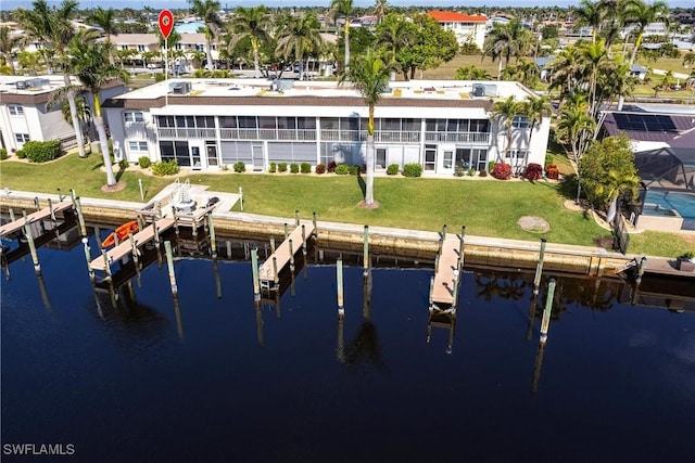 rear view of house with a water view and a lawn