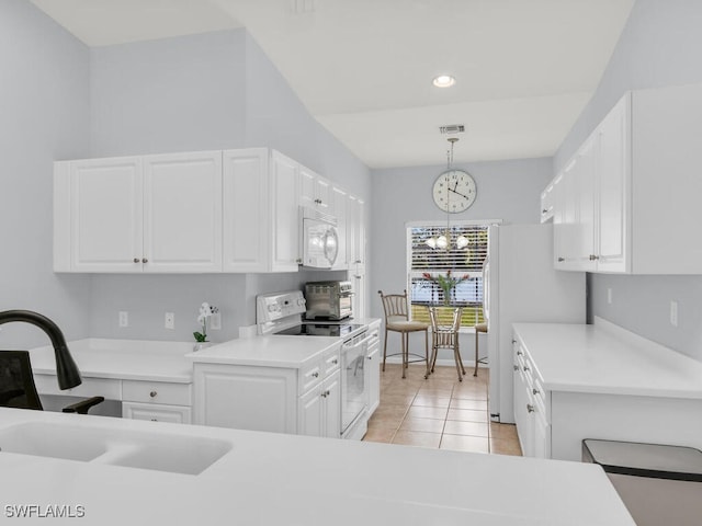 kitchen featuring white cabinetry, sink, hanging light fixtures, a notable chandelier, and white appliances