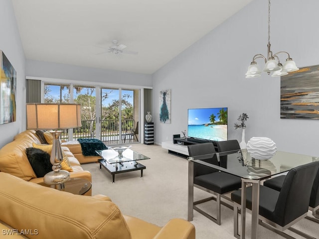 living room featuring light colored carpet, high vaulted ceiling, and ceiling fan with notable chandelier