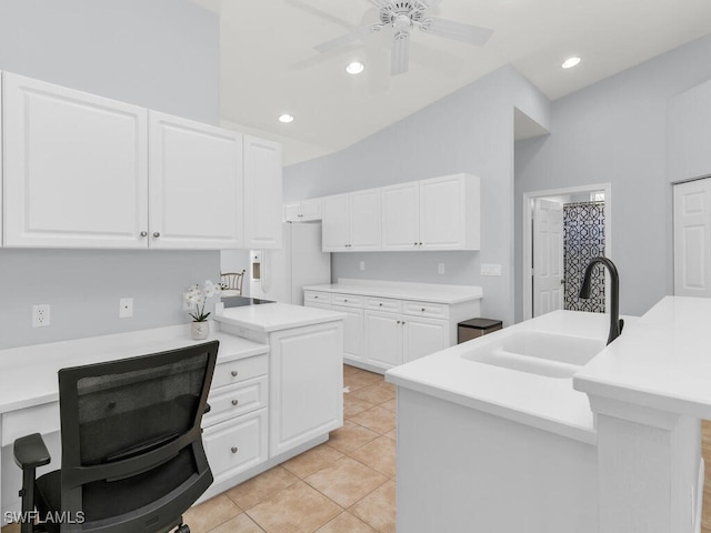 kitchen featuring lofted ceiling, sink, ceiling fan, a kitchen island with sink, and white cabinets