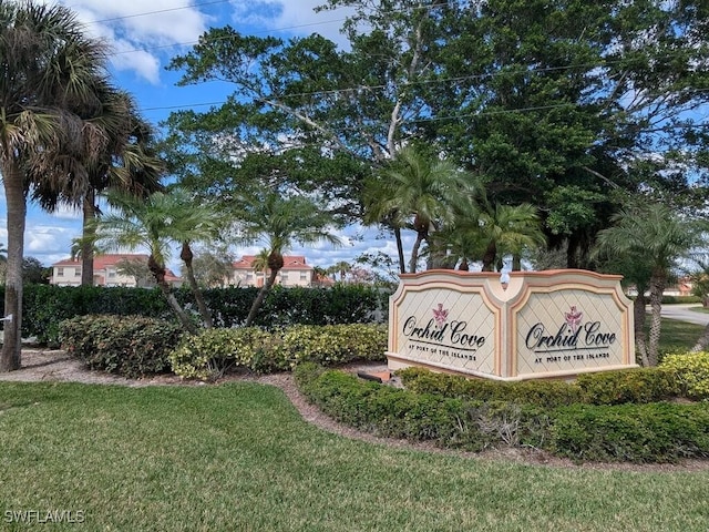 community / neighborhood sign featuring a yard