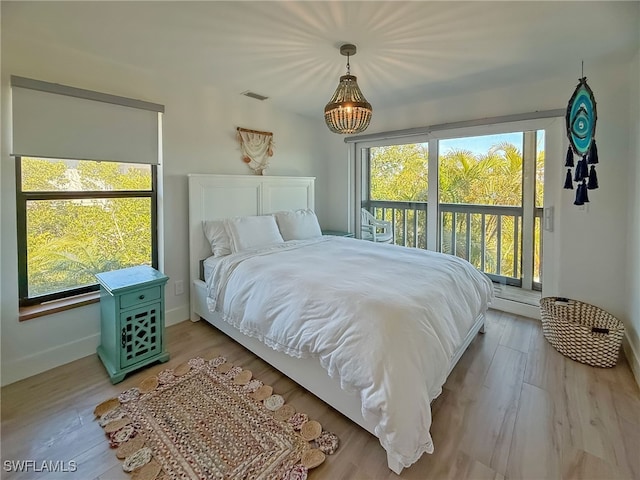 bedroom with light hardwood / wood-style flooring, multiple windows, and access to outside