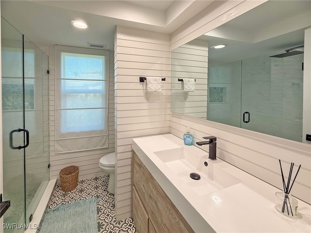 bathroom with vanity, toilet, tile patterned flooring, and a shower with door