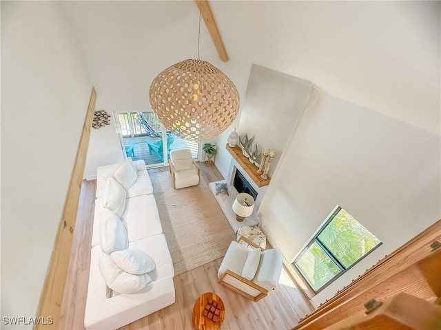 living room featuring a high ceiling, wood-type flooring, and beam ceiling