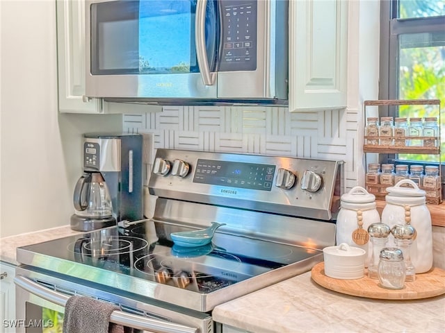 details with white cabinetry, stainless steel appliances, and tasteful backsplash