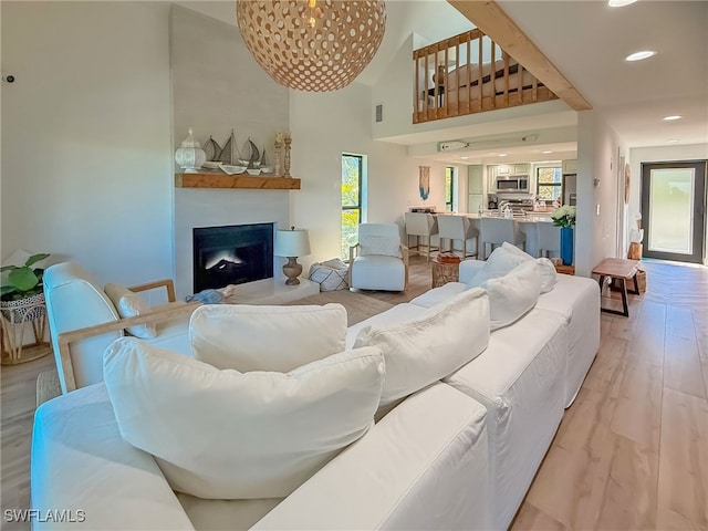 living room featuring a towering ceiling and light wood-type flooring