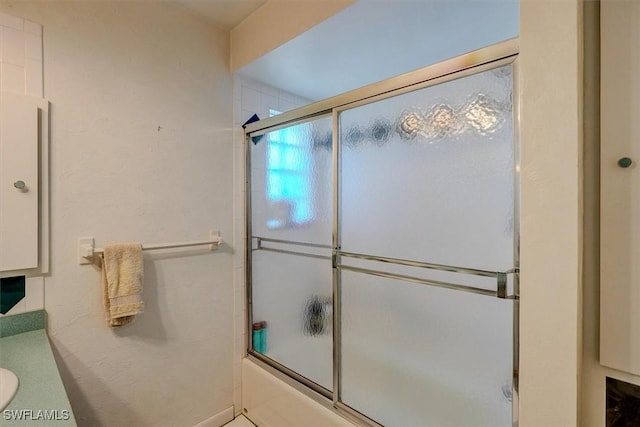 bathroom with vanity and enclosed tub / shower combo