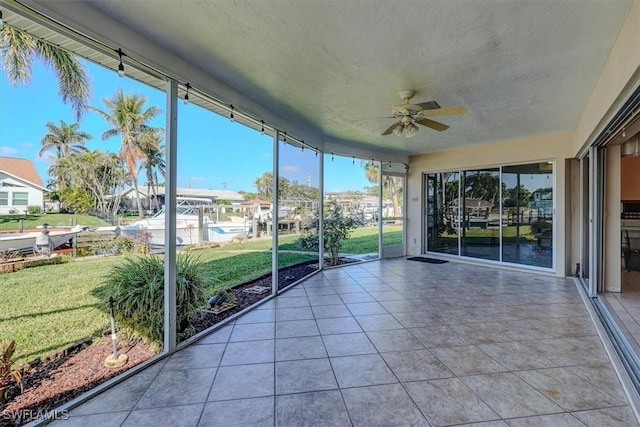 unfurnished sunroom with ceiling fan