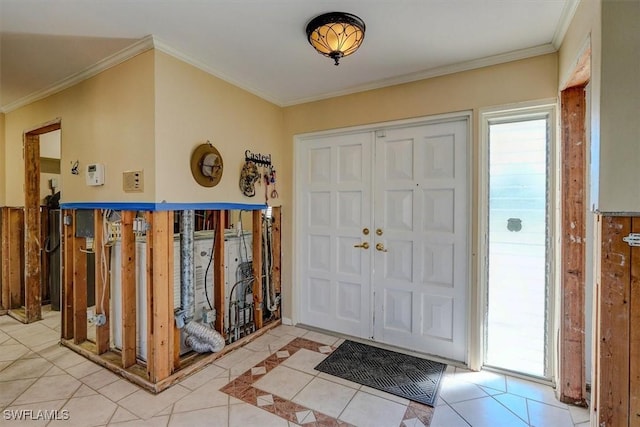 entryway with ornamental molding and light tile patterned floors