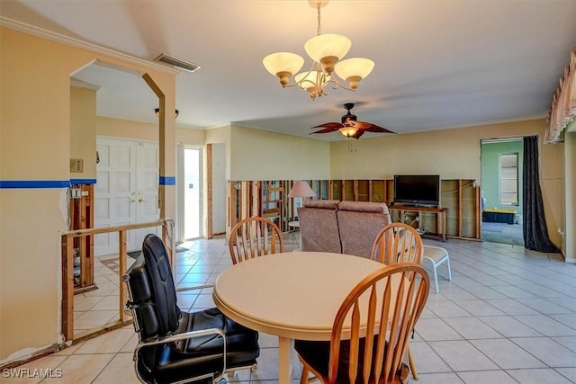 dining area featuring light tile patterned flooring, ornamental molding, and ceiling fan with notable chandelier