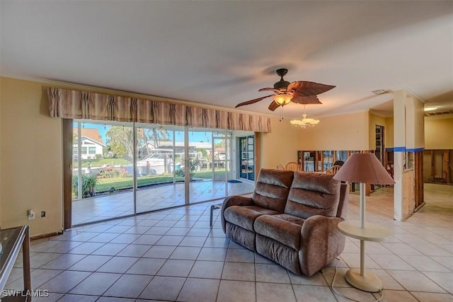 living room featuring ornamental molding, ceiling fan with notable chandelier, and light tile patterned floors