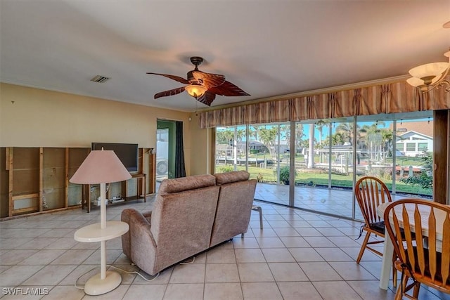 tiled living room featuring crown molding and ceiling fan