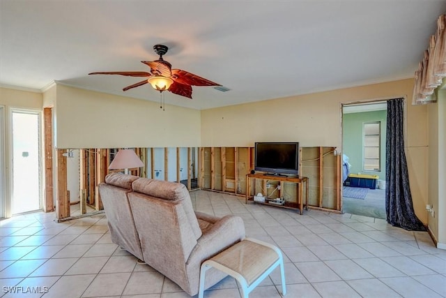 tiled living room featuring crown molding and ceiling fan