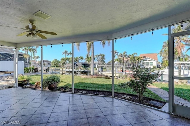 unfurnished sunroom with ceiling fan