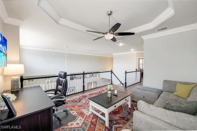 living room with crown molding, visible vents, ceiling fan, and a raised ceiling
