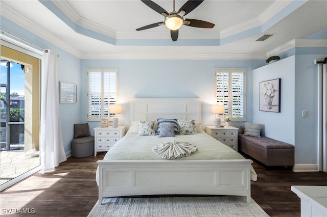 bedroom featuring a tray ceiling, visible vents, access to exterior, and dark wood finished floors