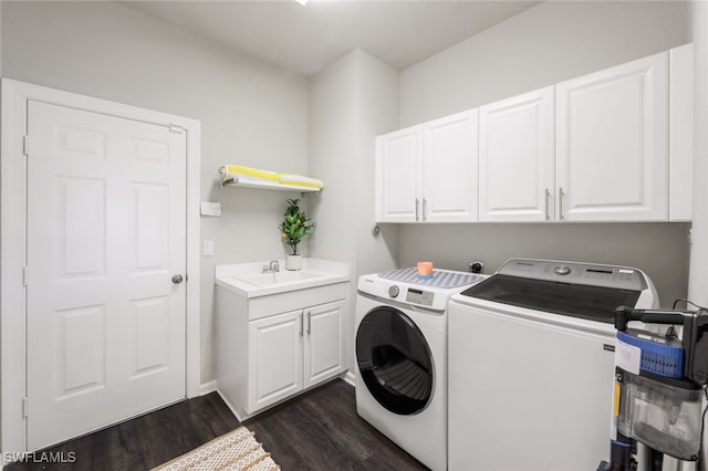 laundry area featuring cabinet space, washer and dryer, a sink, and dark wood finished floors