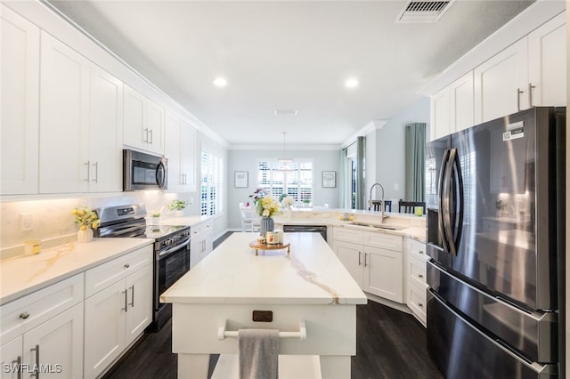 kitchen with stainless steel appliances, visible vents, a sink, a peninsula, and dark wood-style flooring