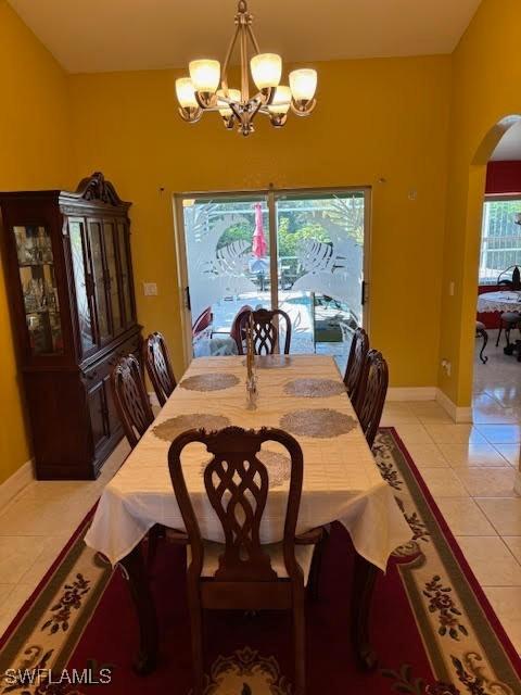 dining area featuring light tile patterned floors and a notable chandelier