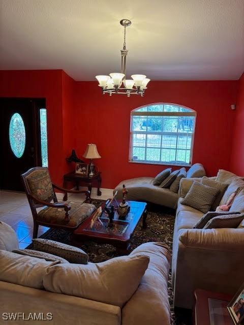 living room with tile patterned flooring and a notable chandelier