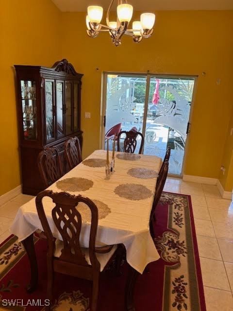 tiled dining room featuring a chandelier