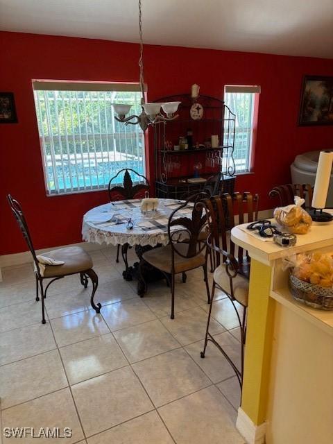 dining room with a chandelier and tile patterned flooring