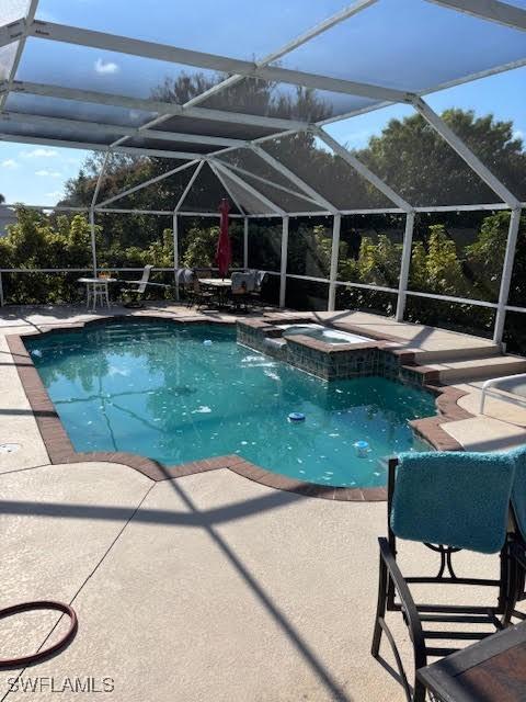 view of pool with an in ground hot tub, a lanai, and a patio