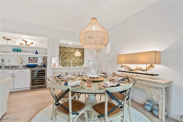 dining room featuring wet bar, wine cooler, and light wood-type flooring