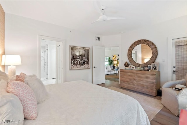 bedroom with ensuite bathroom, light wood-type flooring, and ceiling fan