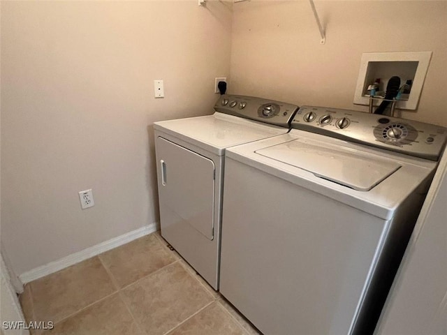 clothes washing area featuring laundry area, independent washer and dryer, baseboards, and light tile patterned floors