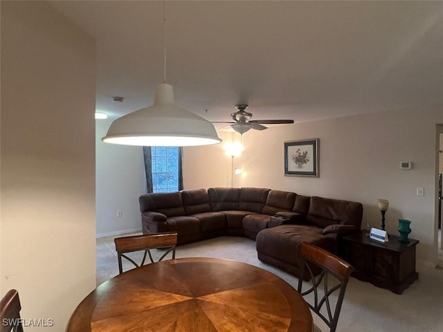 living area with ceiling fan and light colored carpet