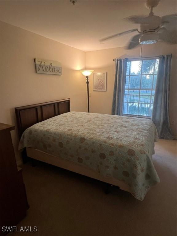 bedroom featuring dark carpet and a ceiling fan