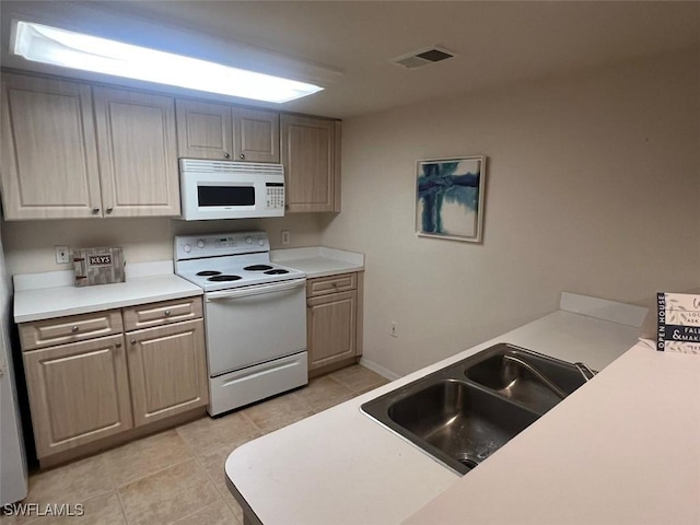 kitchen with white appliances, light tile patterned floors, visible vents, light countertops, and a sink