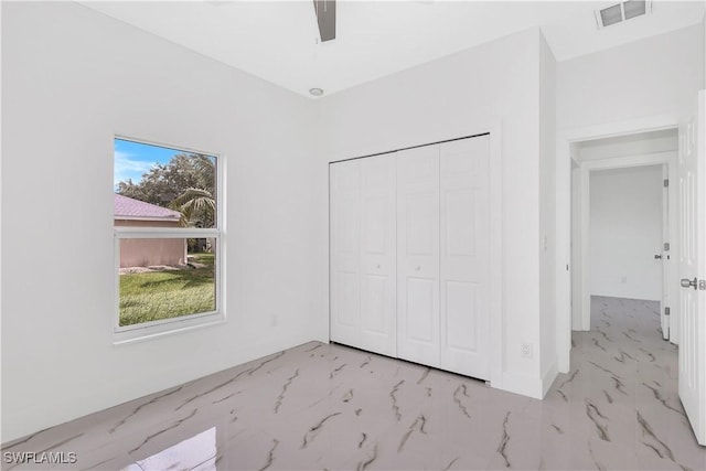 unfurnished bedroom with ceiling fan and a closet