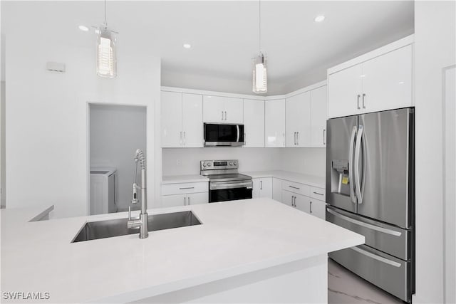 kitchen featuring stainless steel appliances, sink, pendant lighting, and white cabinets