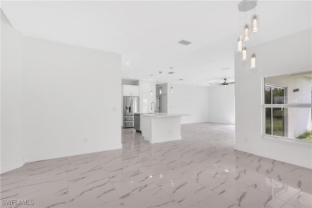 unfurnished living room featuring sink and ceiling fan