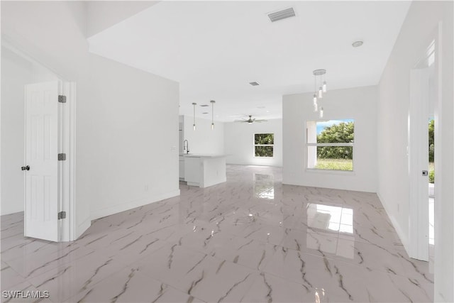 unfurnished living room featuring sink and ceiling fan