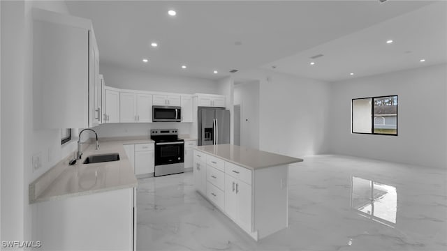 kitchen featuring sink, stainless steel appliances, a center island, light stone countertops, and white cabinets