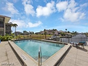 community pool with a patio and fence