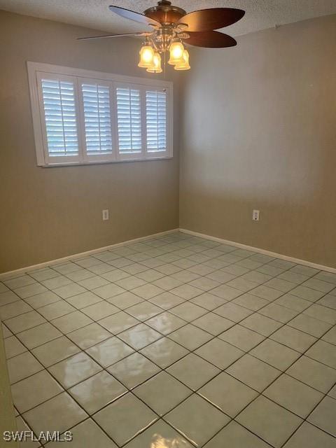 spare room with baseboards, a textured ceiling, and a ceiling fan