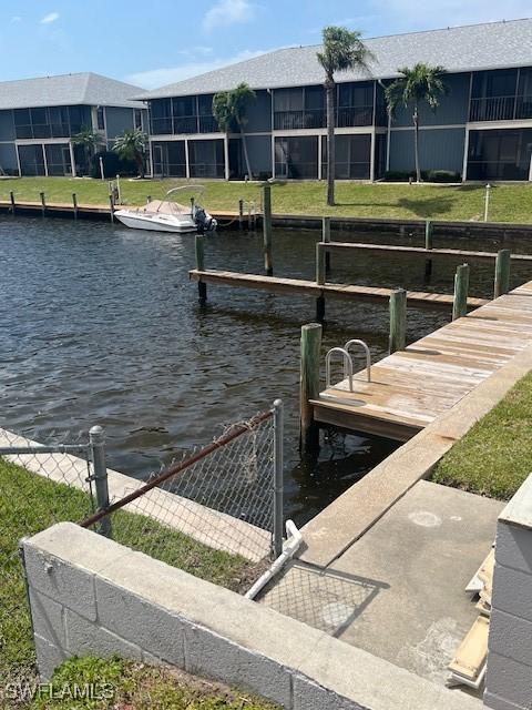 view of dock featuring a water view and fence