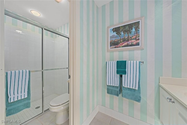 bathroom with toilet, vanity, tile patterned floors, a stall shower, and wallpapered walls